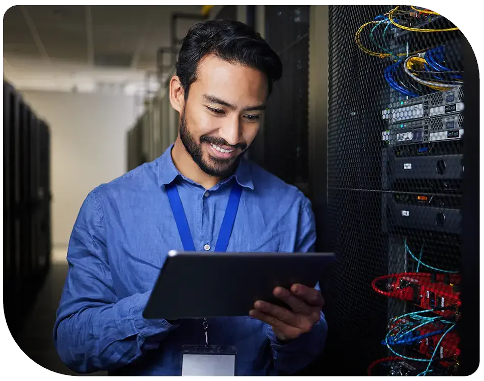 man working on tablet in front of servers