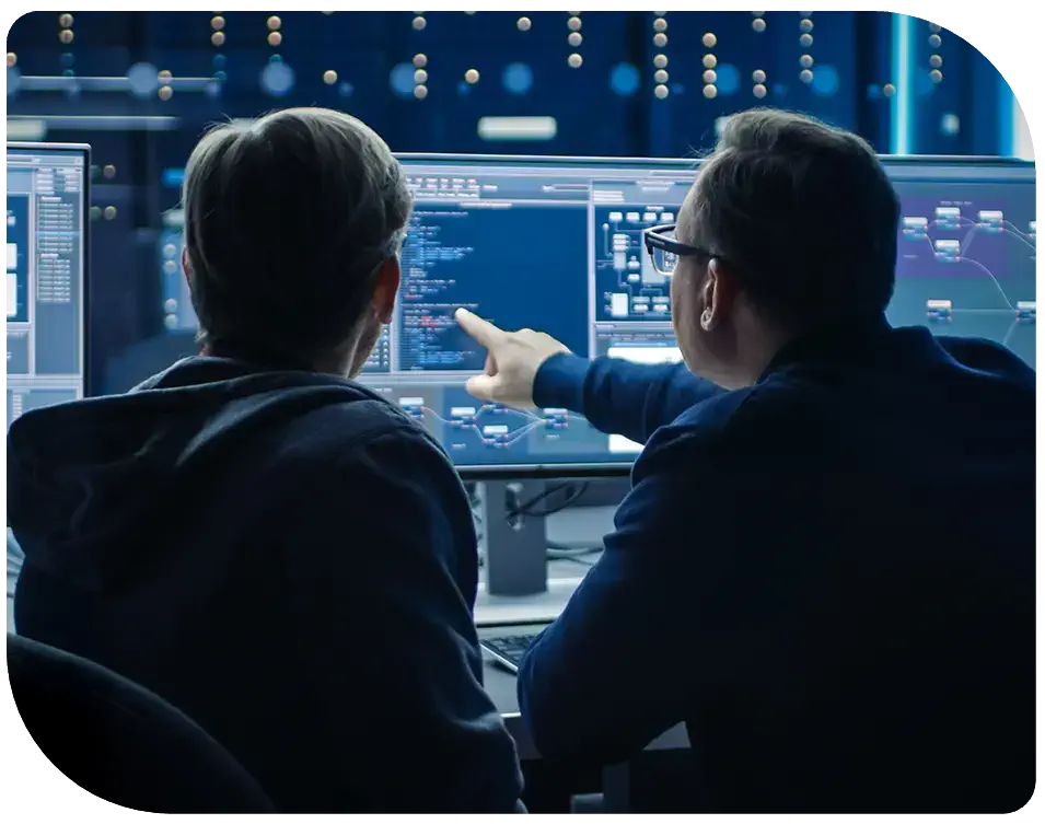 two people working in a data center, with one pointing at a monitor